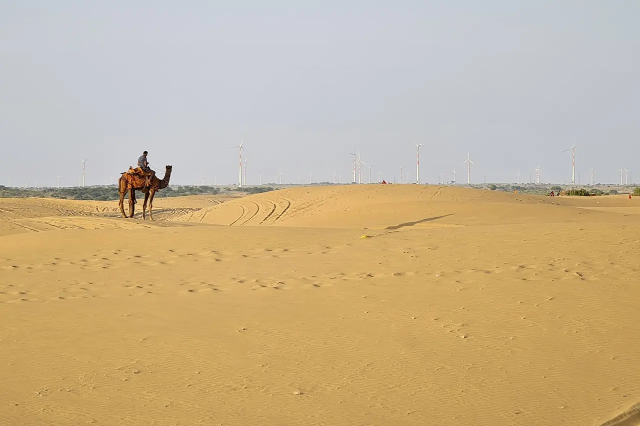 A camel rider crossing the Thar desert at dusk near Jaisalmer