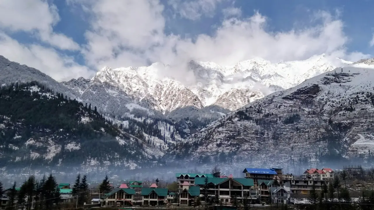 Snow on the high Himalayan peaks above a clear, snow-free Kullu valley in Himachal Pradesh