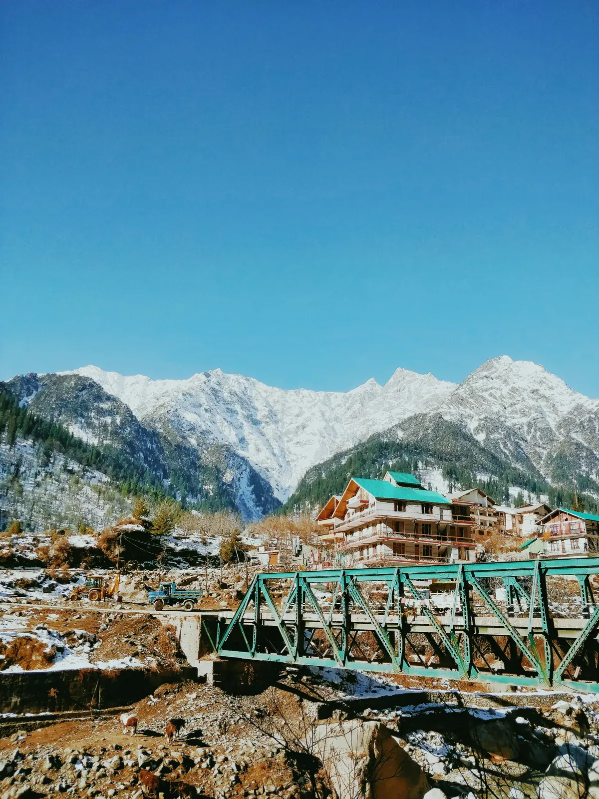 Snow-capped mountains above a green valley in Manali, Himachal Pradesh