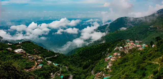 A hill town on a forested ridge above the clouds in Uttarakhand