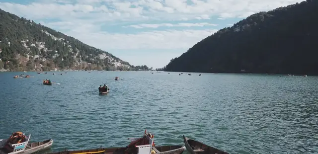 Wooden boats on the lake below forested hills at Nainital, Uttarakhand